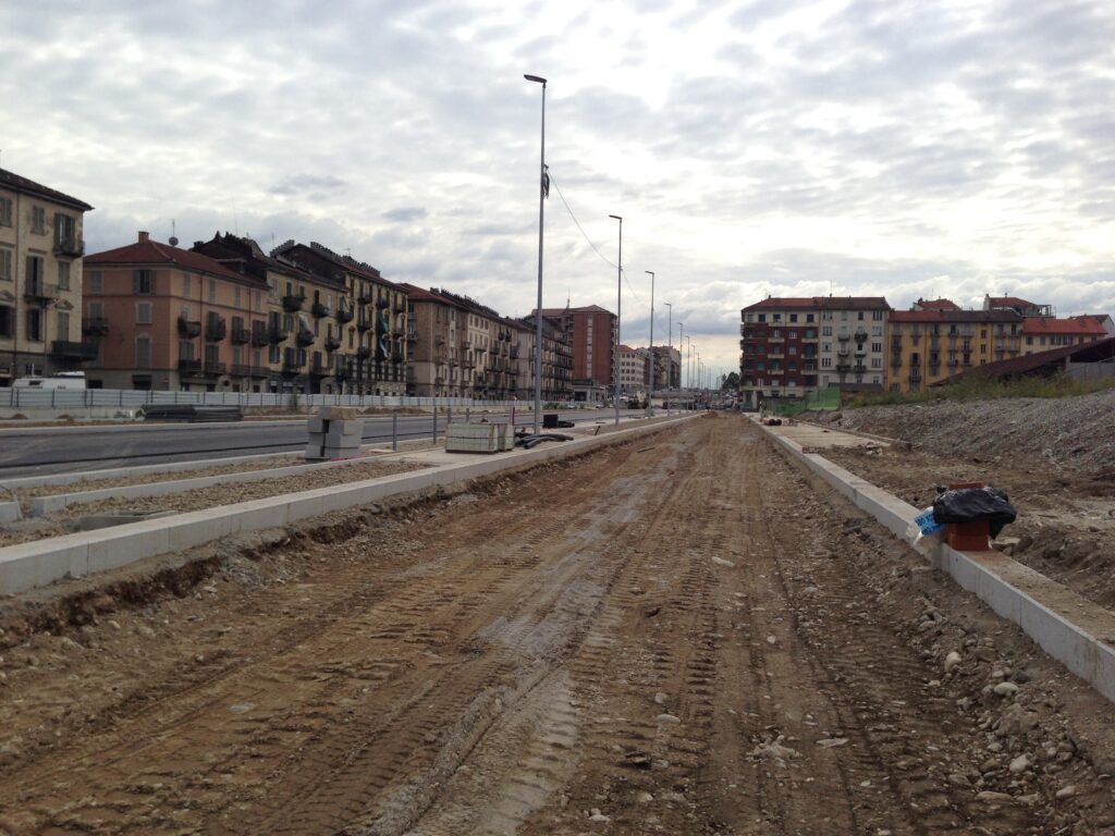 Cantiere stradale con cordoli in cemento per carreggiata urbana, forniture edili in pietra.